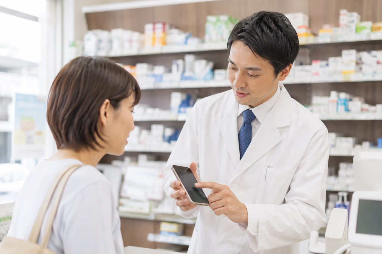 お薬手帳アプリを案内する薬局の業務と教育を解説します。について確認する薬剤師のイメージ